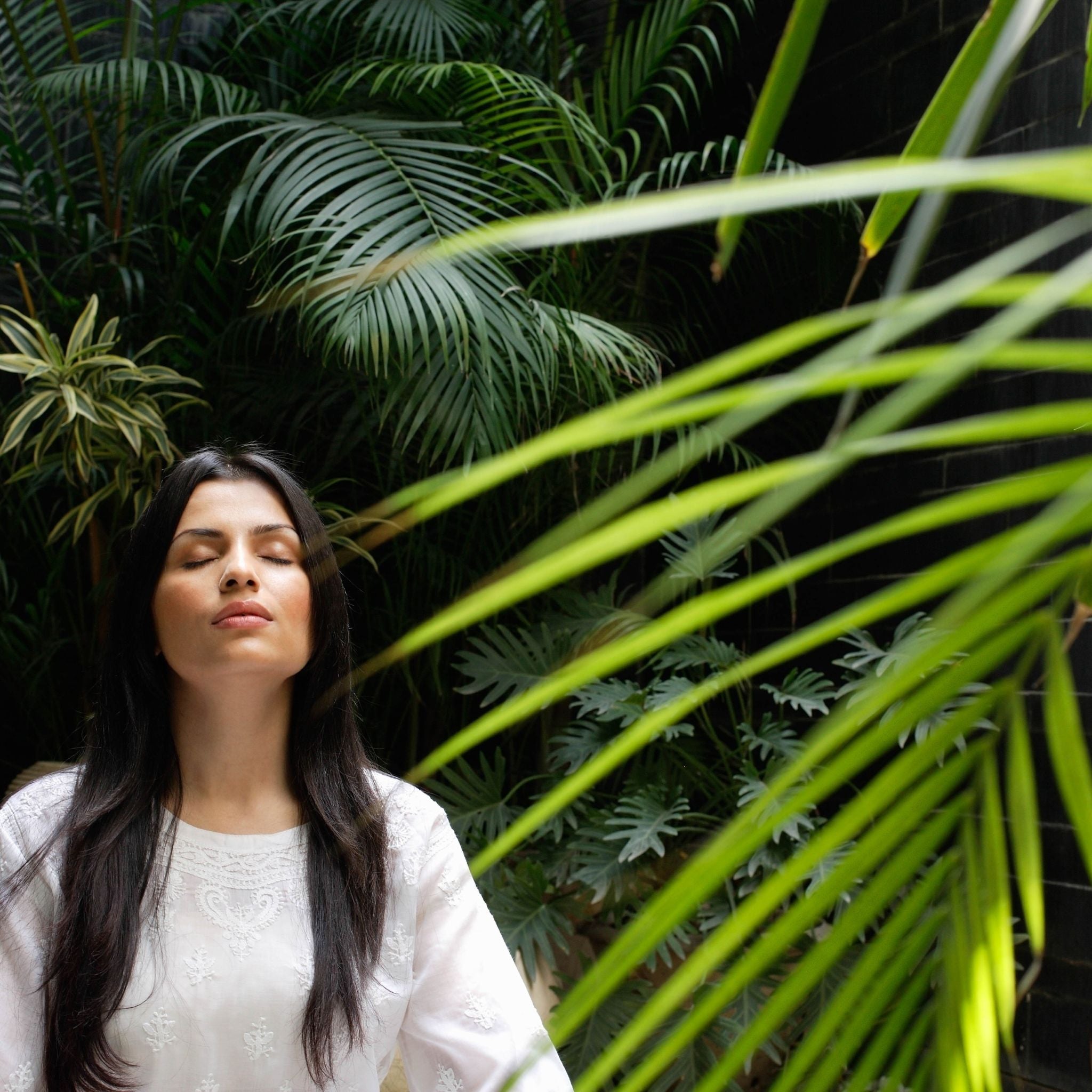 Woman relaxing in tropical foliage
